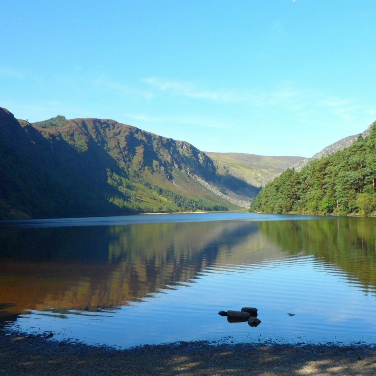 Explore the serene landscapes of Glendalough where crystal-clear waters reflect the majestic Wicklow Mountains offering a peaceful retreat amidst Ireland's stunning natural beauty.