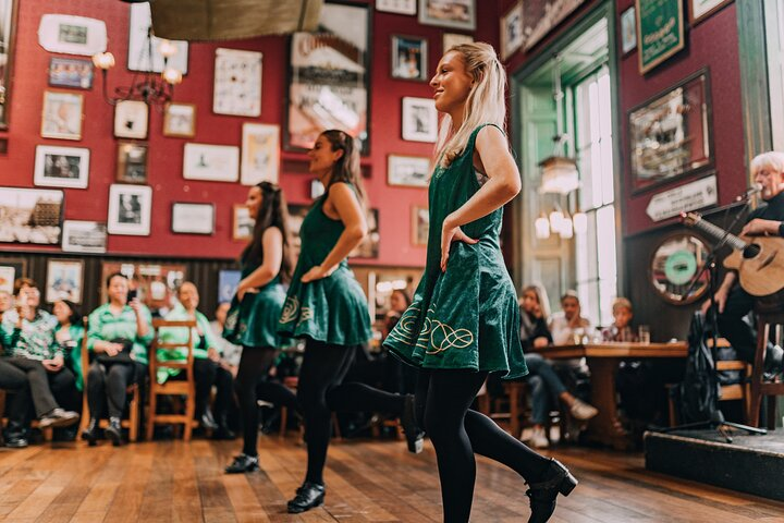 Experience the joy of Irish culture as talented dancers showcase traditional moves while a live singer adds charm to your evening at a cozy Dublin pub. Enjoy a pint and the lively entertainment!