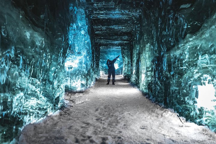Journey through a magnificent ice cave where crystalline walls shimmer in ethereal blue revealing the raw beauty of Iceland's glaciers. A unique adventure awaits inside this icy wonder.