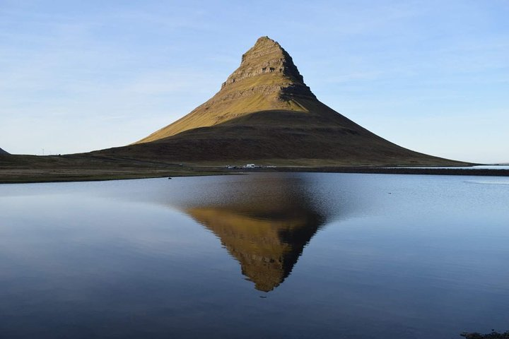 Majestic Kirkjufell rises from serene waters revealing Iceland's unique natural wonders. Explore legendary landscapes filled with history and tales of adventure that spark the imagination.