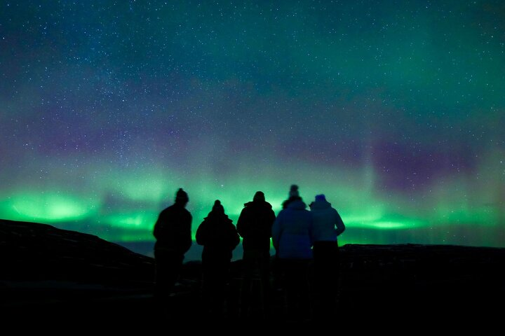 Experience the magic of the aurora borealis with warm blankets hot cocoa and pastries while creating lasting memories under Iceland's night sky with expert guides capturing your adventure.