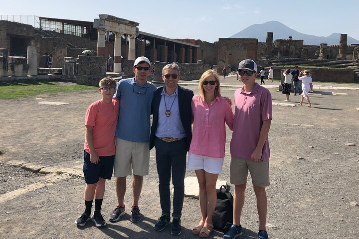 Giuseppe with a nice family in the Forum of Ancient Pompei. In the background the silhouette of Mount Vesuvius. 