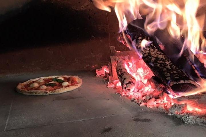 Pizza into the wood-fire oven