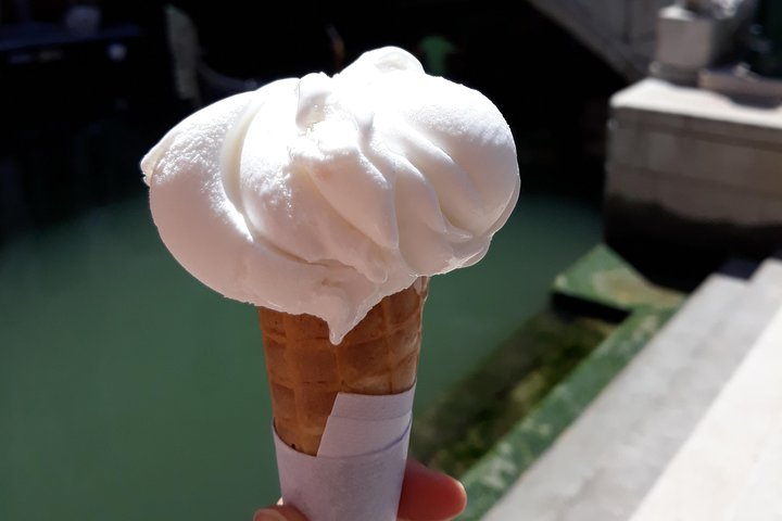 Indulge in creamy gelato against the serene backdrop of Venice’s canals perfectly complementing your journey through local cuisine and charming hidden gems. Taste tradition in every bite!