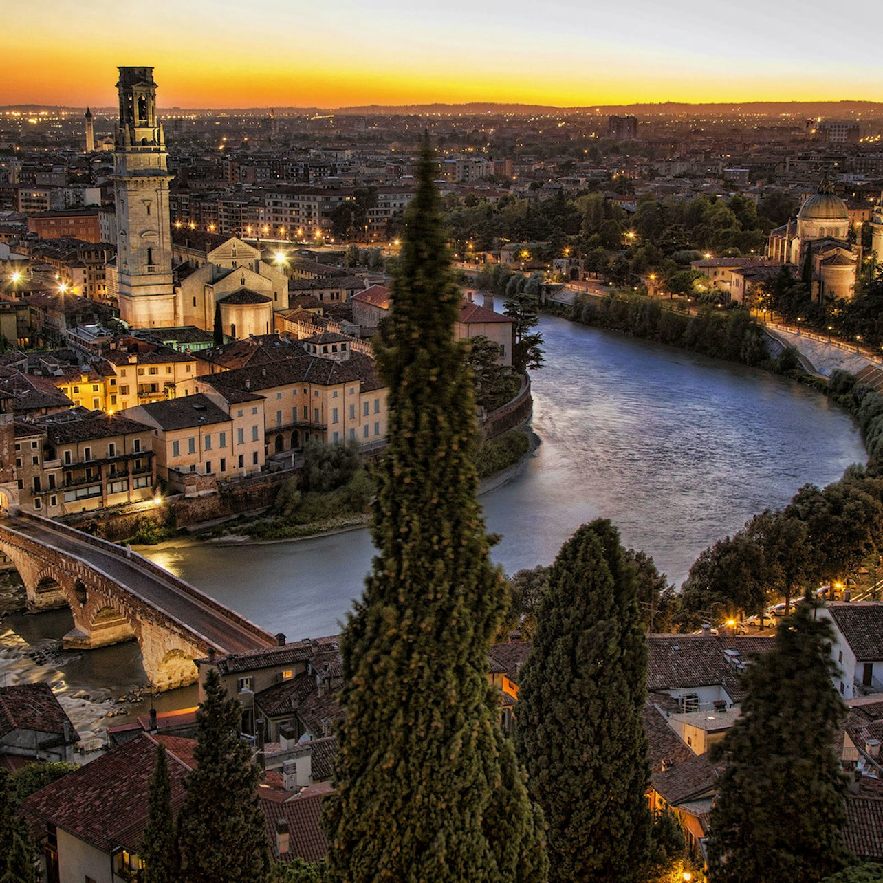 Experience the charm of Verona’s historic skyline at dusk where ancient architecture meets serene waters creating a picturesque backdrop for exploration and discovery in this timeless Italian city.