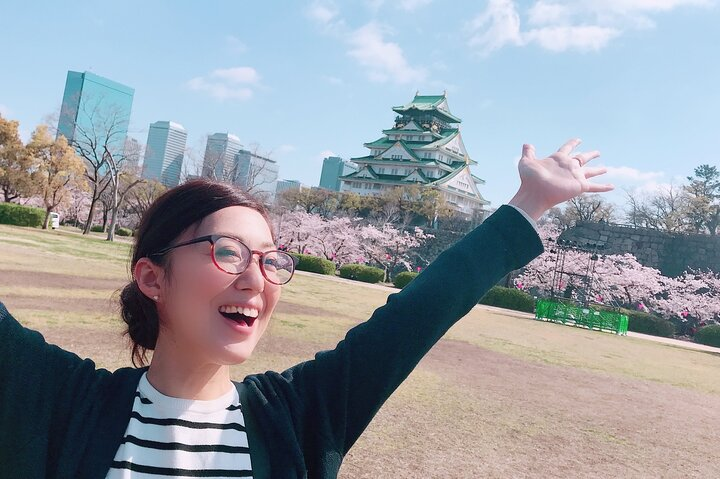Capture joyful moments against the stunning backdrop of Osaka Castle and blooming cherry blossoms creating lasting memories amidst the city's unique blend of tradition and modernity.