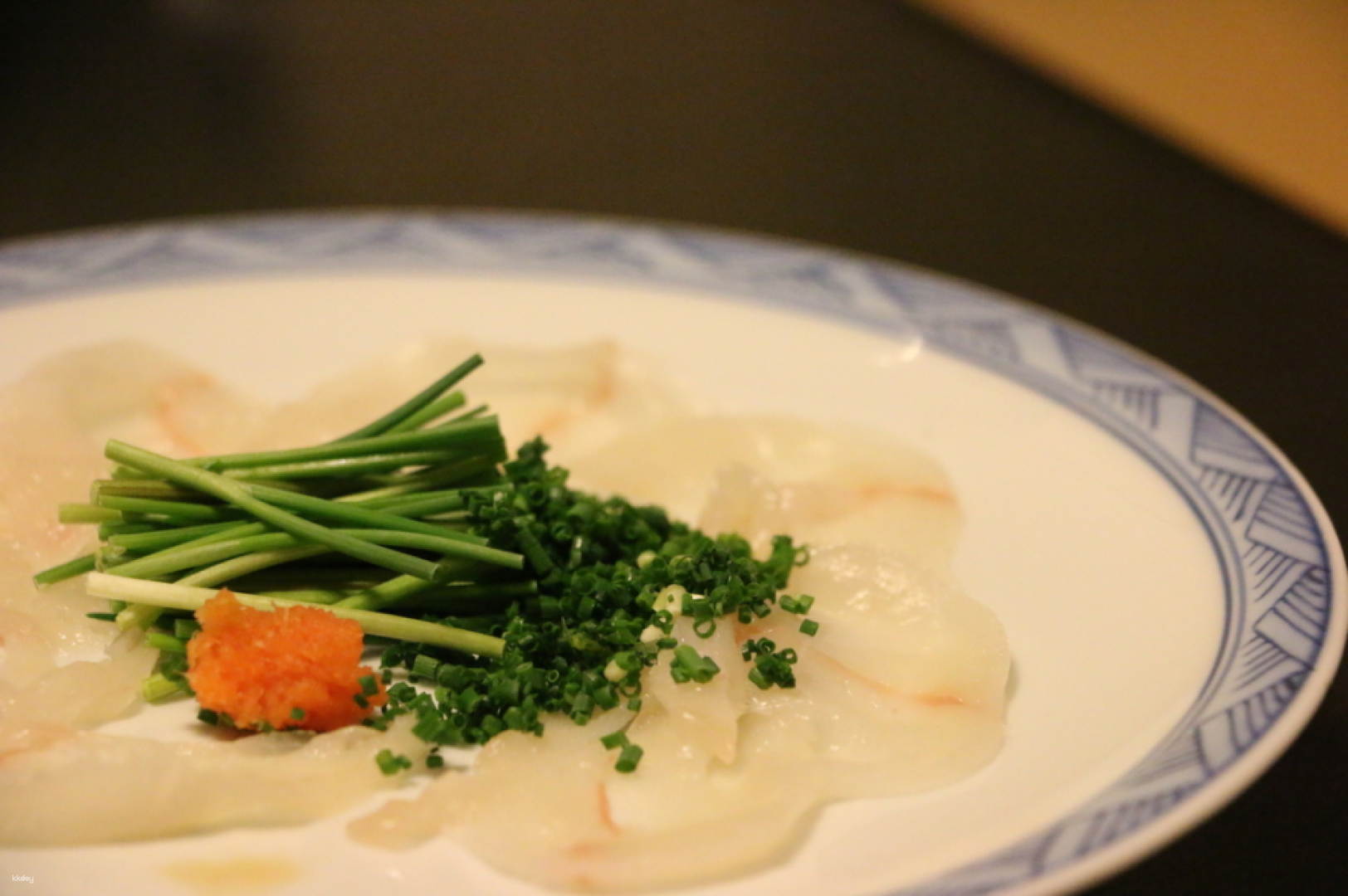 Experience the unique flavors of Osaka with hand-sliced tiger puffer fish sashimi where each taste celebrates generations of culinary expertise in an inviting Japanese eatery.