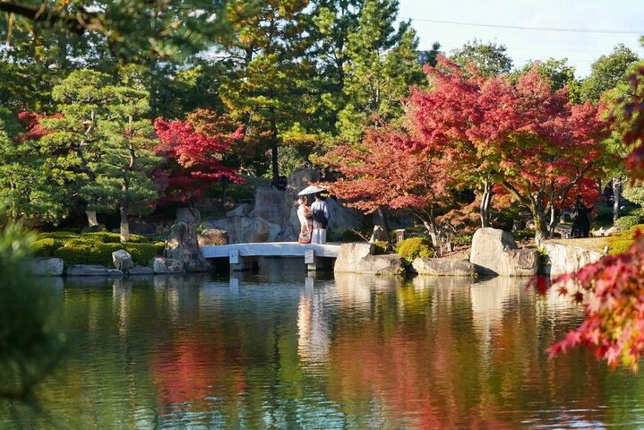 Experience the serene beauty of Nagoya's autumn as you stroll through Tokugawa Garden surrounded by striking foliage and tranquil waters capturing the essence of Japanese culture.