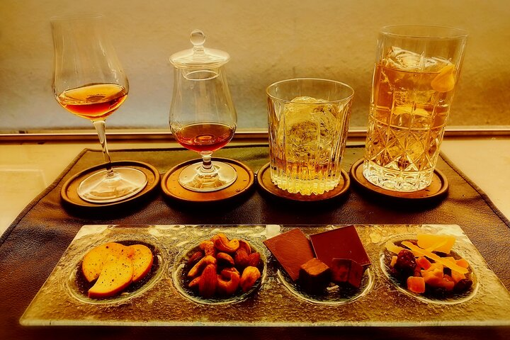 Savor the elegance of rare Japanese whiskies paired with hand-cut ice as delicious snacks complement the experience in an inviting private bar setting perfect for whiskey enthusiasts.