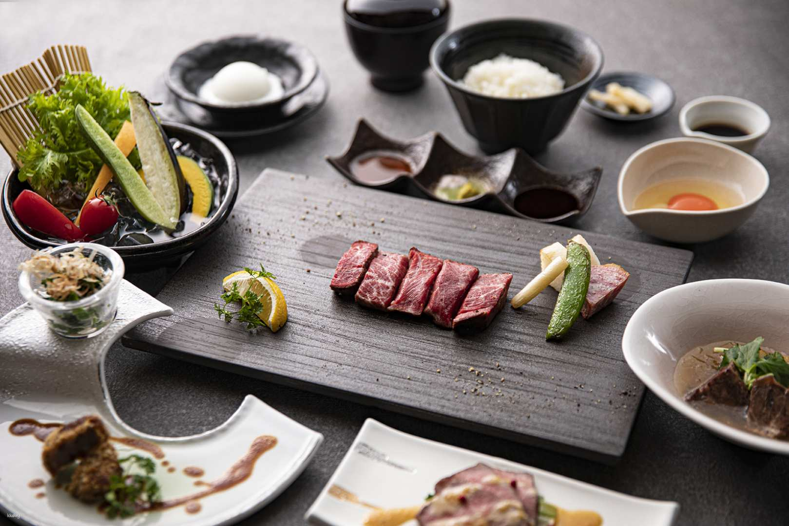 Savor the exquisite flavors of rare Japanese Black Wagyu beef beautifully presented alongside fresh accompaniments in a serene elegant setting perfect for an unforgettable dining experience.