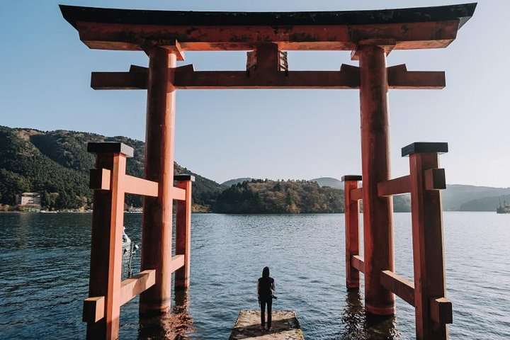 Experience Japan's rich culture as you stand beneath the majestic torii gate surrounded by serene waters and stunning landscapes a perfect moment for reflection and discovery on your journey.