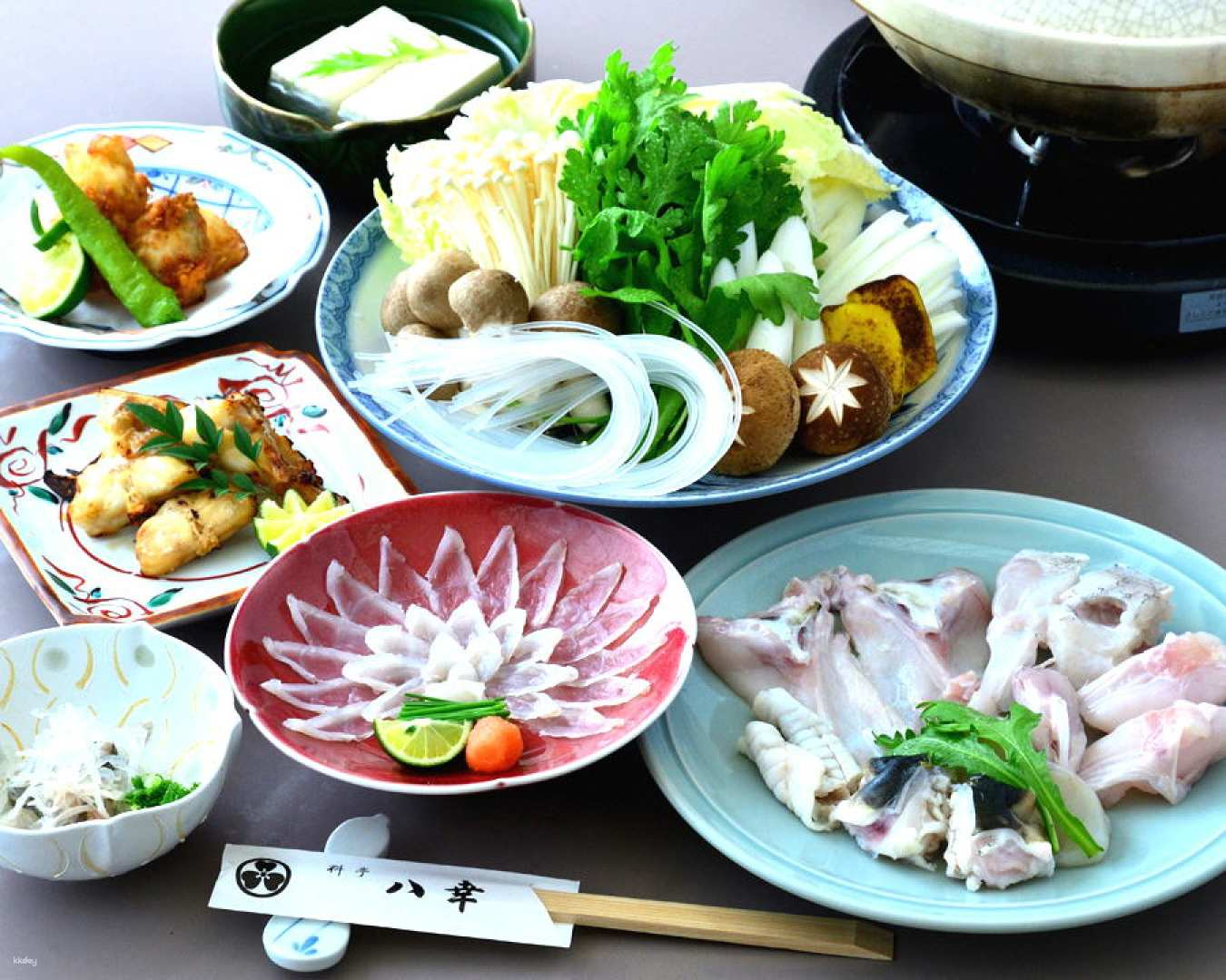 Savor exquisite dishes of blowfish and A5 grade Saga beef in a comfortable dining setting perfect for food enthusiasts exploring the culinary delights of Osaka.