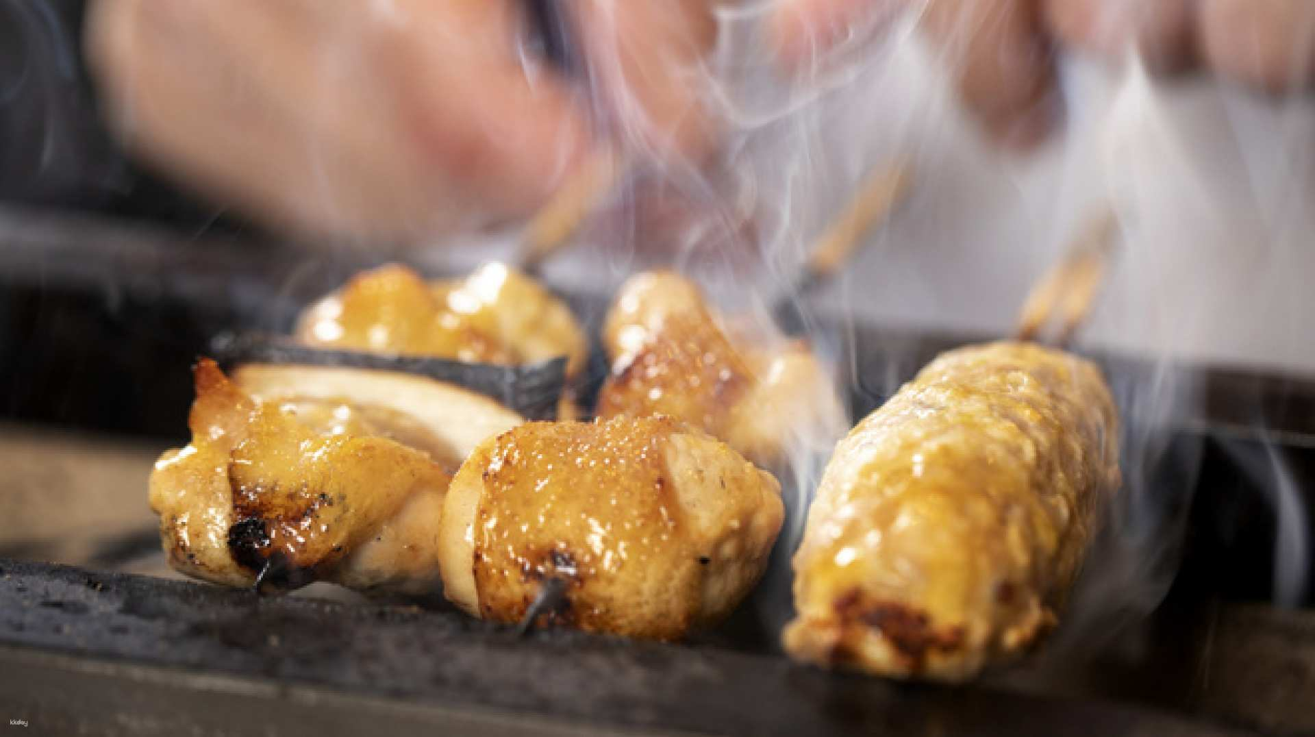 Indulge in the rich flavors of meticulously grilled black Satsuma chicken skewers perfectly paired with refreshing drinks creating a memorable culinary experience in Tokyo.