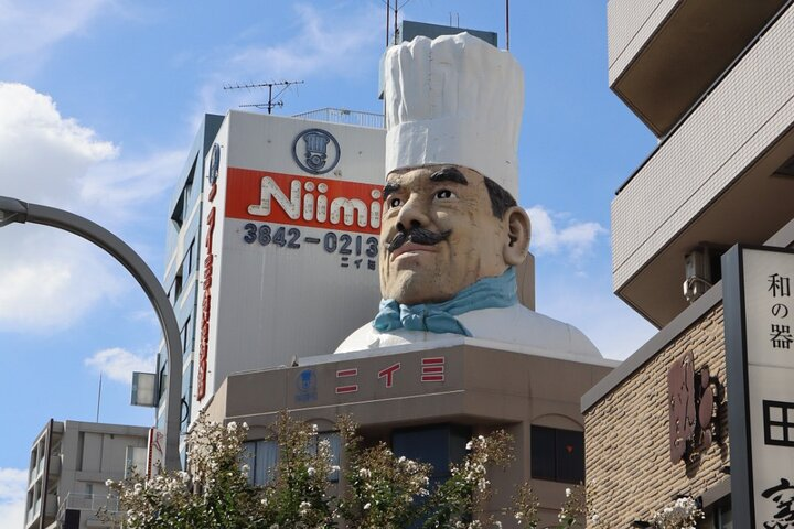 Discover the charm of Kappabashi with its oversized chef statue a symbol of culinary creativity inviting visitors to explore exquisite tableware and the art of replica food crafting.