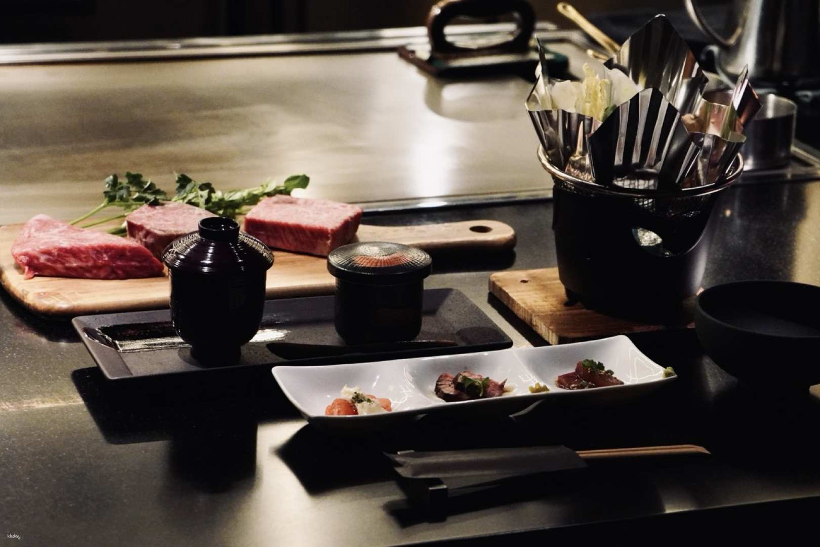 Experience the elegance of FUJIWARA STEAK HOUSE with finely prepared Takachiho beef beautifully showcased amidst a stylish counter setting perfect for a memorable culinary journey in Tokyo.