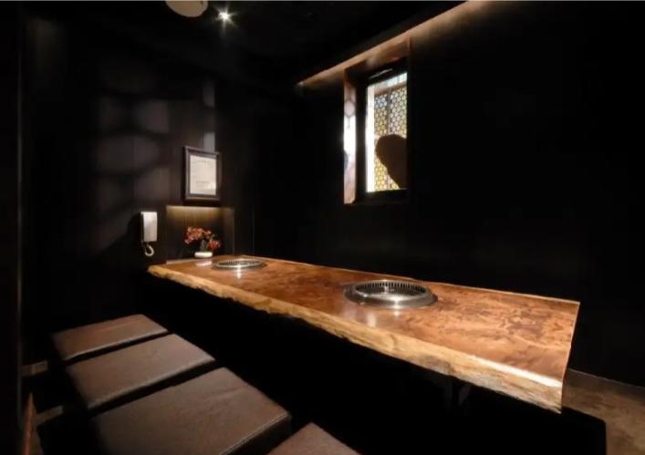 A cozy setting awaits featuring a unique wooden table and intimate seating for enjoying top-grade Kuroge Wagyu. Savor the rich flavors of fresh expertly grilled offal in style.