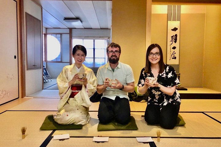 Experience the serene elegance of a traditional tea ceremony while savoring sweet treats surrounded by beautiful tea utensils in a classic Japanese setting perfect for culture enthusiasts.