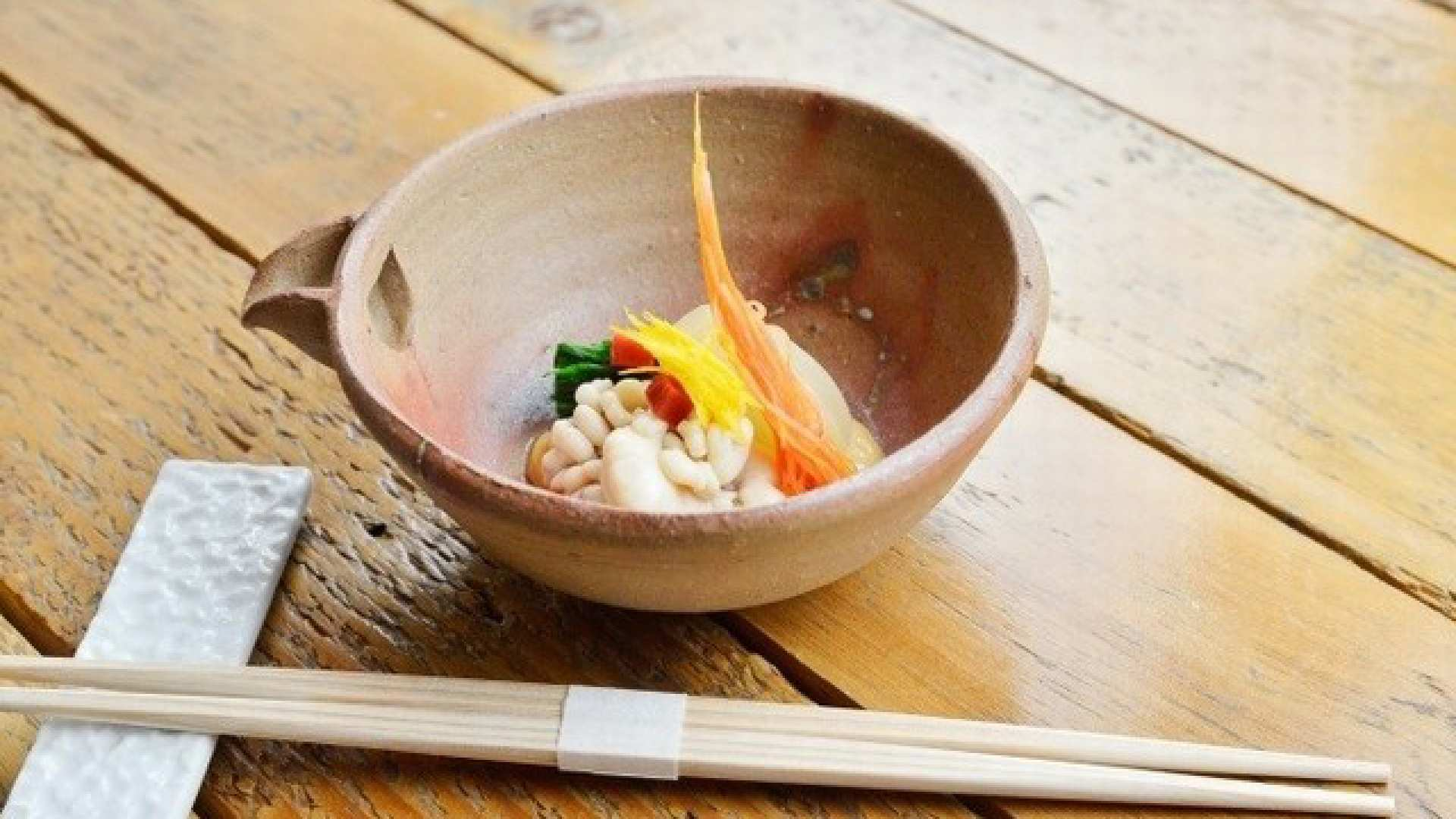 Indulge in beautifully plated dishes crafted from fresh seasonal ingredients all set against the rustic charm of wooden tableware inviting a memorable dining experience in Hokkaido.