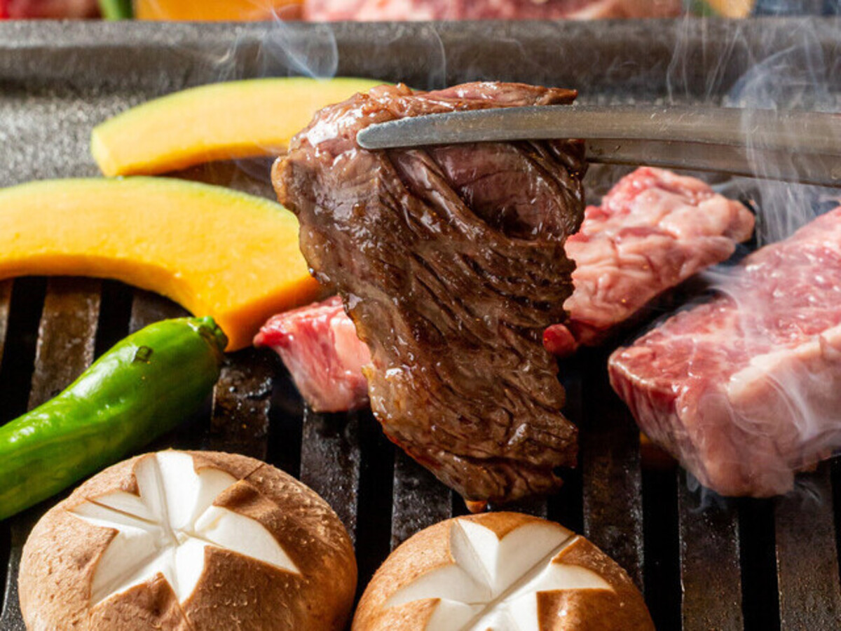 Experience the unique Itamae Yakiniku style as you savor the exquisite A5 rank female beef expertly grilled right at your table complemented by locally sourced veggies for an unforgettable culinary delight.