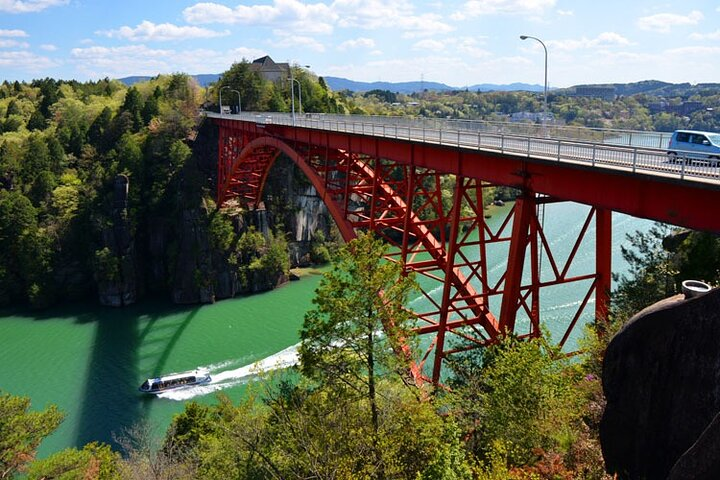 Experience the stunning natural beauty of Ena Gorge where a red bridge spans emerald waters inviting exploration of scenic views and tranquil landscapes enhancing your journey through central Japan.