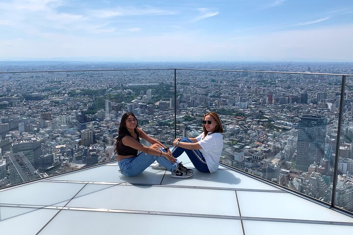 Experience the breathtaking views of Tokyo from Shibuya Sky capturing unforgettable moments with friends amidst the sprawling skyline and iconic cityscape. A perfect adventure awaits.