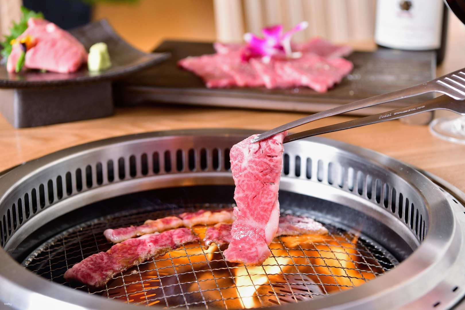 Savor premium Kuroge Wagyu as it grills to perfection surrounded by a stylish setting. Experience a culinary journey through Japan's finest beef preparations in a chic dining environment.