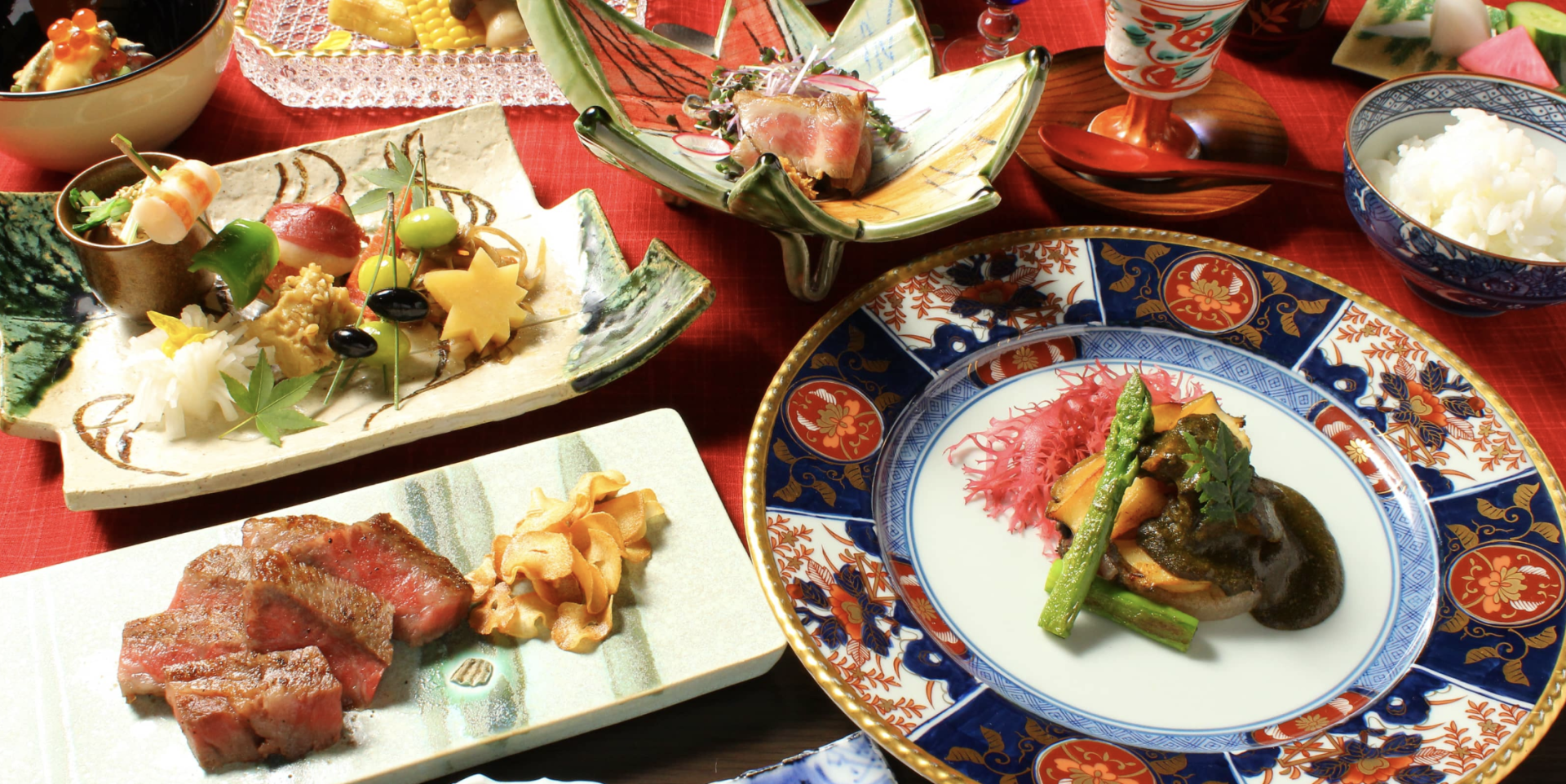 Experience the artistry of Japan’s culinary scene with expertly crafted dishes like duck liver chawanmushi and black beef steak all presented in a beautifully arranged setting.