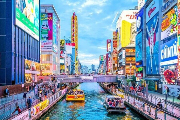 Experience the lively streets of Osaka where illuminated billboards reflect on the water bustling boats glide through scenic canals and diverse eateries promise delightful culinary discoveries.