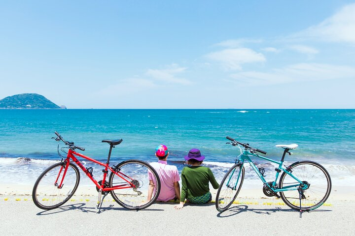 Explore the stunning coastline of Shikanoshima Island while cycling alongside friends. Experience a blend of rich history and natural beauty on this charming island getaway in Fukuoka.
