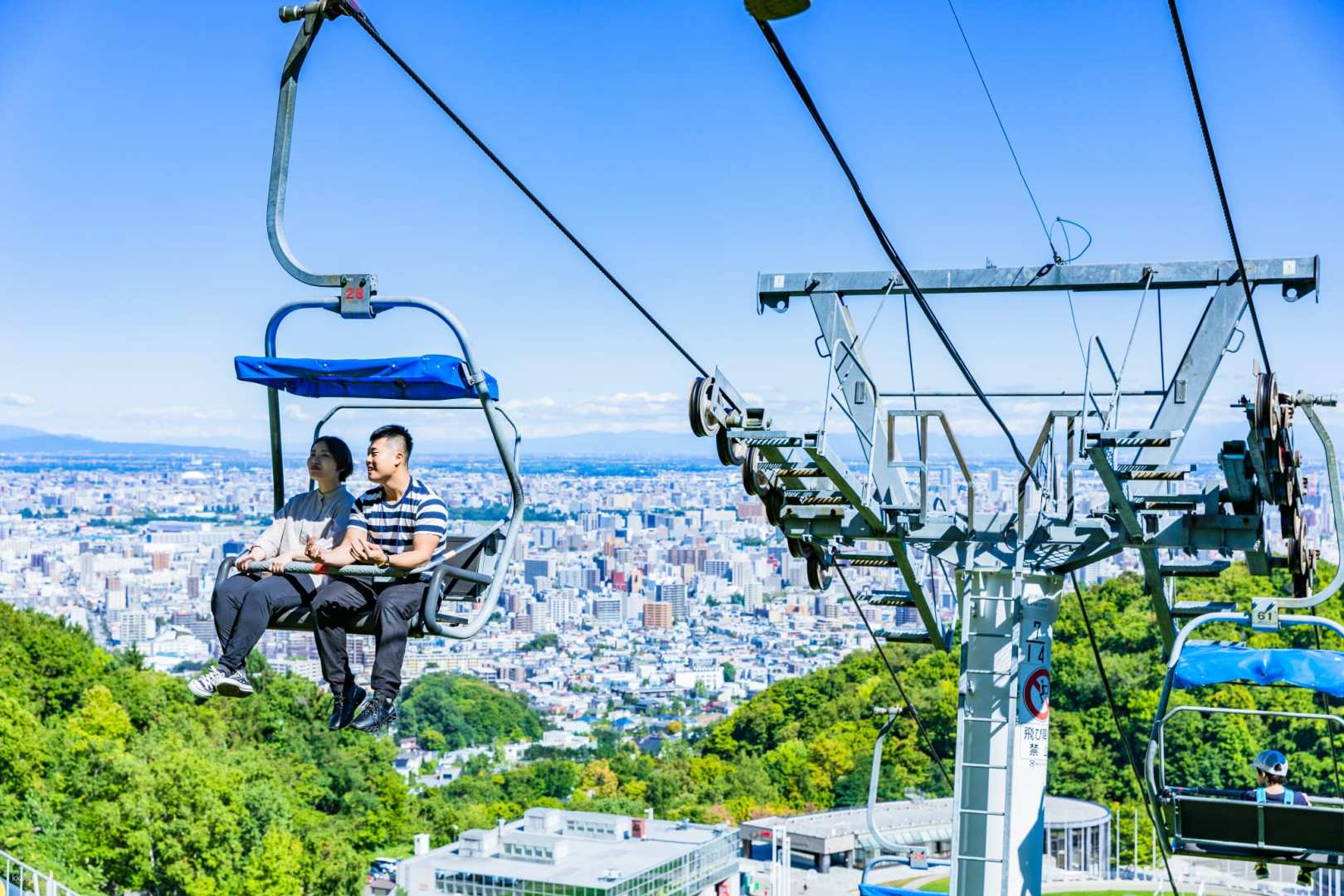 Glide high above Sapporo on the lift enjoying sweeping views of the city and the majestic Ishikari Plain promising an unforgettable experience and stunning photo opportunities.