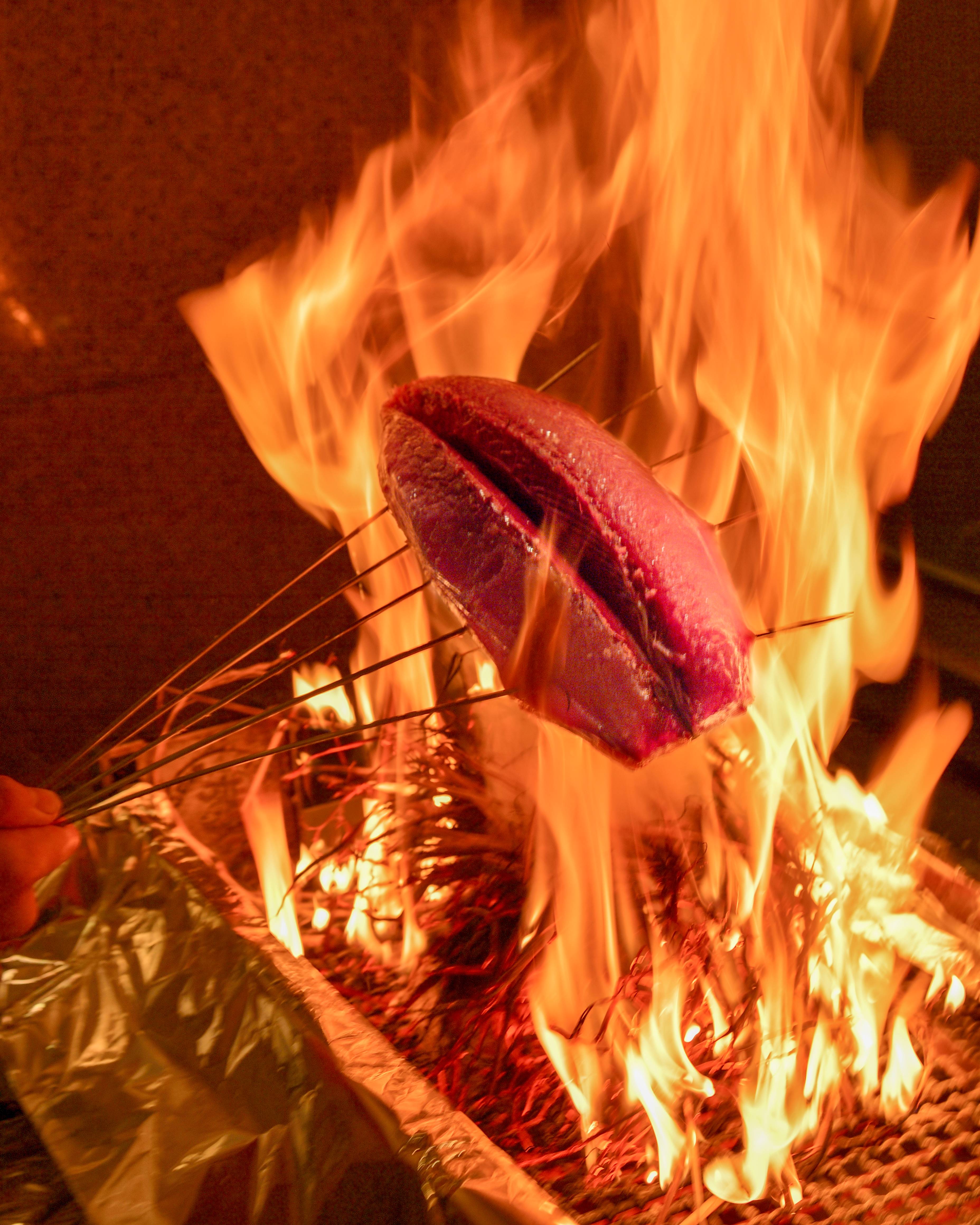 Experience the sizzle of gourmet Sendai beef as it cooks over open flames accompanied by a selection of Tohoku sake and fine wines perfect for enriching your culinary journey.