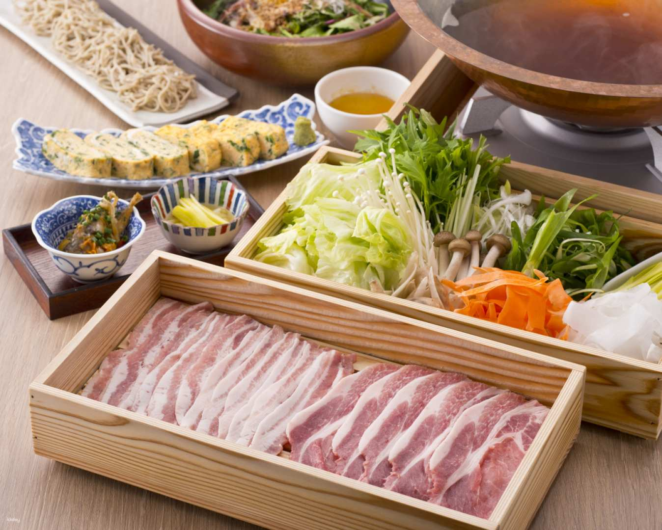 Indulge in a memorable dining experience with tender Satsuma Kurobuta and delicate bonito dashi surrounded by an array of flavorful dishes perfect for sharing with friends.