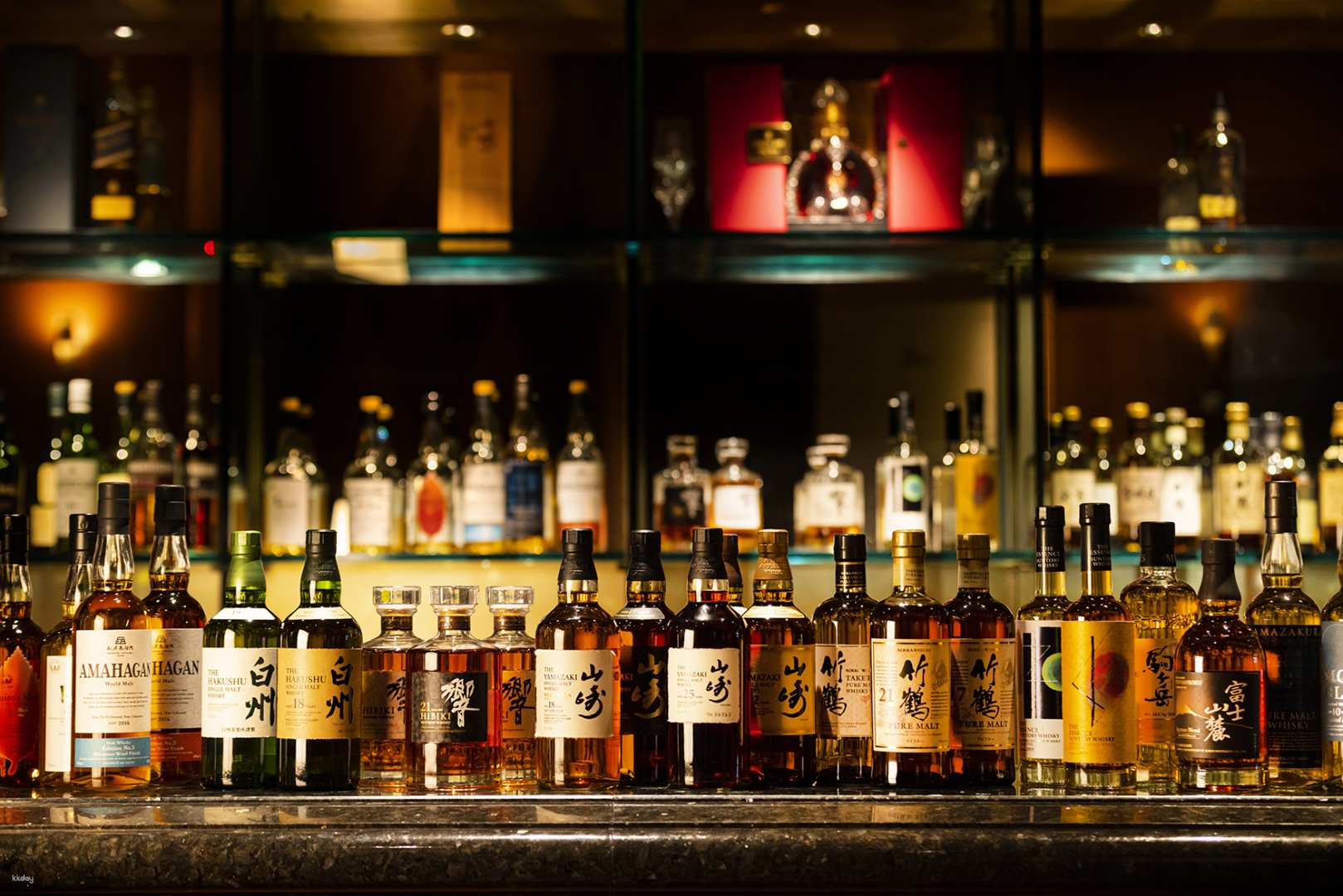 Indulge in an array of exquisite Japanese whiskeys at Captain's Bar where skilled bartenders craft delightful cocktails amidst a refined setting perfect for relaxation after a day of exploring Tokyo.
