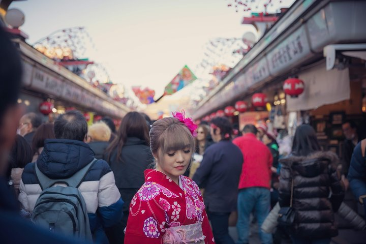Experience the charm of Tokyo as you stroll through vibrant markets capturing moments in traditional attire surrounded by colorful stalls and the lively energy of city life.