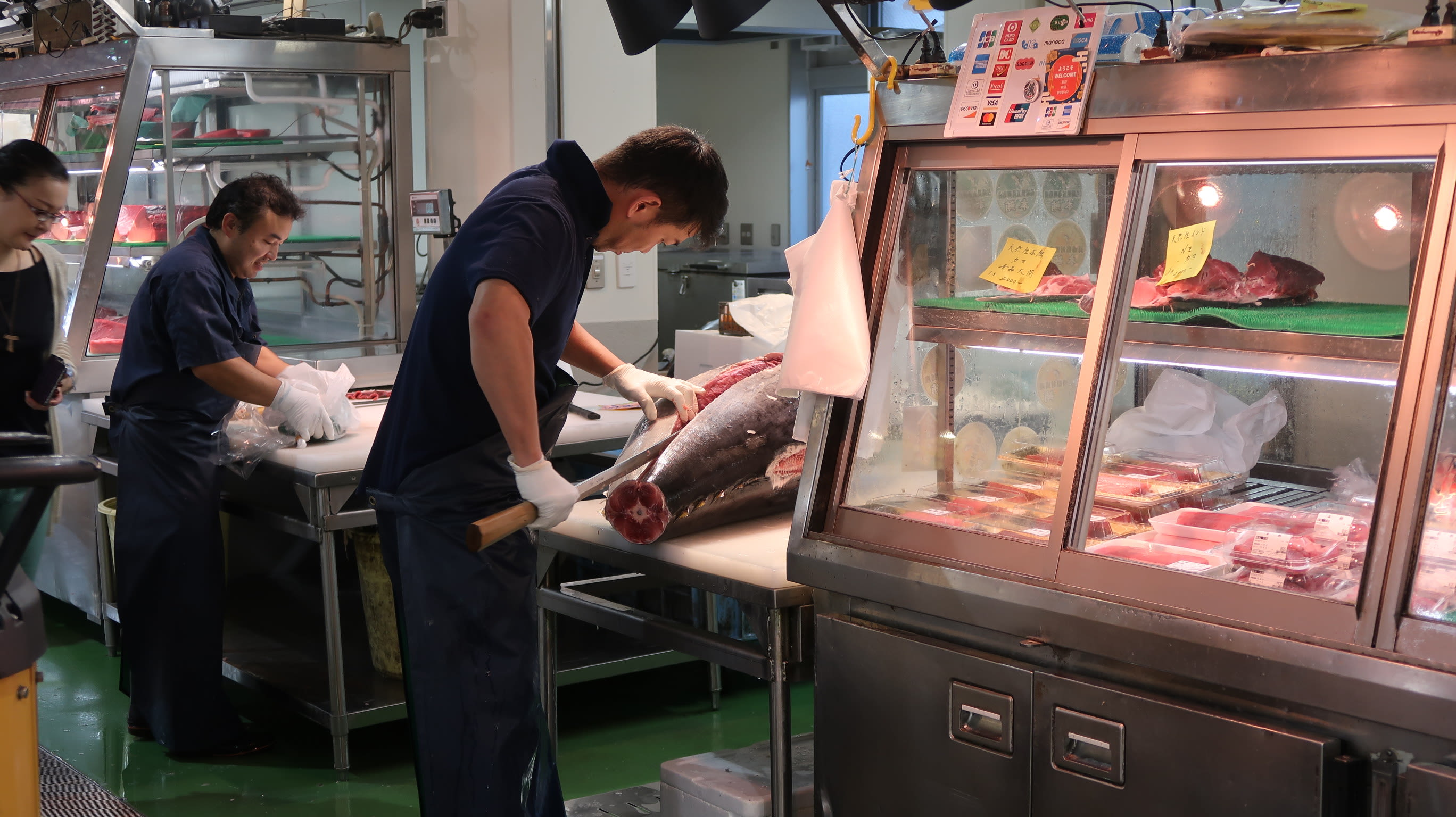Witness the art of preparation as skilled chefs expertly work with fresh tuna showcasing the craftsmanship and dedication behind Tokyo's renowned seafood culture at the Toyosu Fish Market.