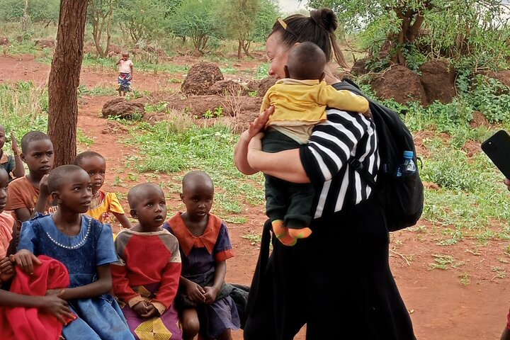 A visitor interacting with Masai children 