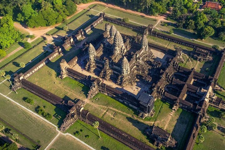 Explore the majestic Angkor Wat temple surrounded by lush greenery showcasing intricate architecture and rich history. Witness the stunning sunset from Bakheng mountain for an unforgettable experience.
