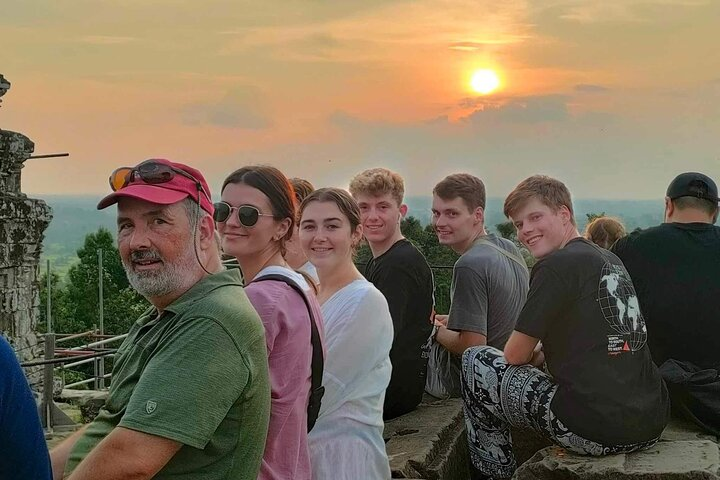 Experience the beauty of twilight at Phnom Bakheng as the sun sets over ancient temples creating a perfect moment to connect with history and fellow travelers.