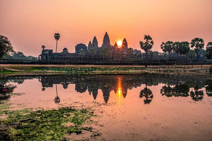 Experience the magic of sunrise over Angkor Wat where shimmering reflections and ancient silhouettes create an unforgettable moment blending history and nature seamlessly in Siem Reap.
