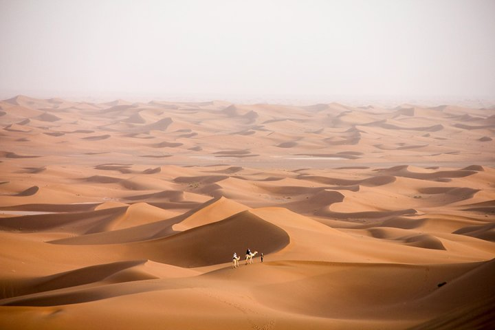 Across the Sahara Desert. There is nothing around you and you can hear the camel's footsteps on the soft sand.