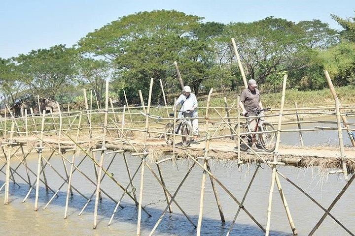 Bikers crossing over bamboo bridge