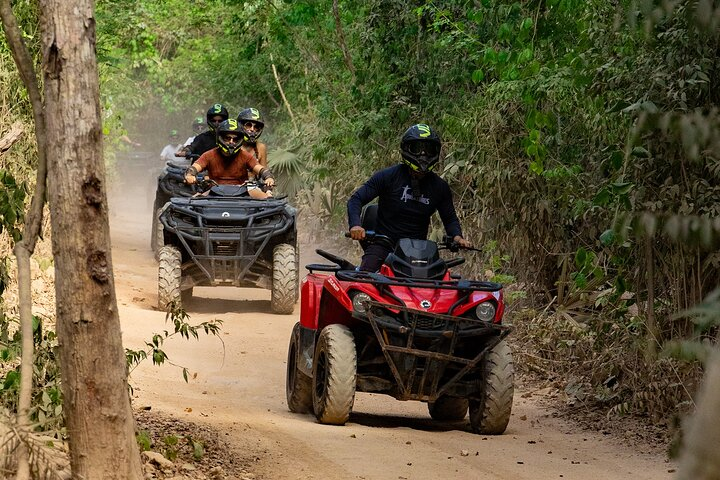 Family on Can-Am ATVs navigating the jungle of the Riviera Maya in the Mexican Caribbean.