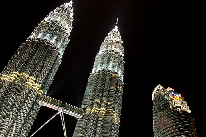 Experience the iconic Petronas Twin Towers illuminated at night a stunning backdrop for a day filled with exploration and cultural discovery throughout Kuala Lumpur and beyond.