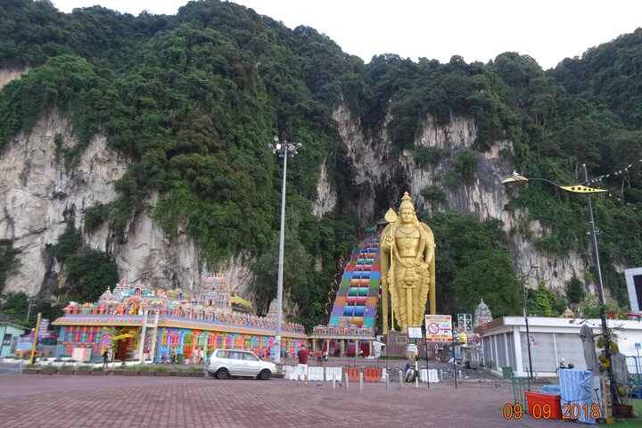 Experience the majestic Batu Caves where towering limestone cliffs cradle a stunning golden statue offering travelers a glimpse into Malaysia's rich culture and heritage. Discover its secrets!