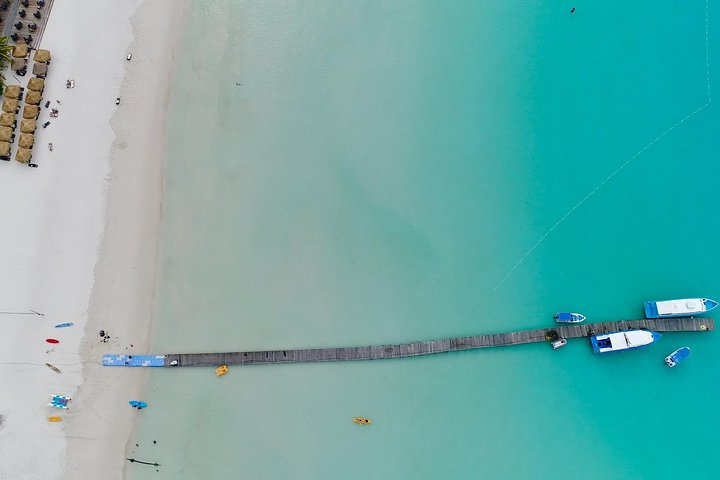 Experience the serenity of a pristine beach with tranquil waters where you can unwind and savor local flavors all while enjoying a private transfer—your adventure awaits!