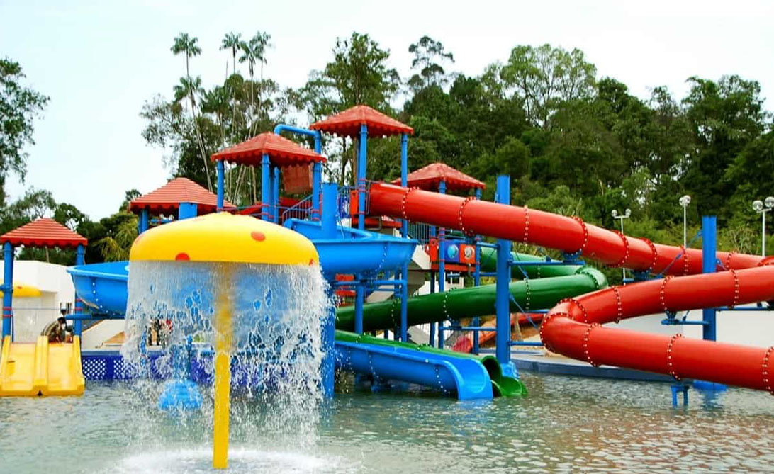 Experience the fun of Melaka Wonderland where colorful slides and playful water features create a day of excitement for families and friends amid lush green surroundings.