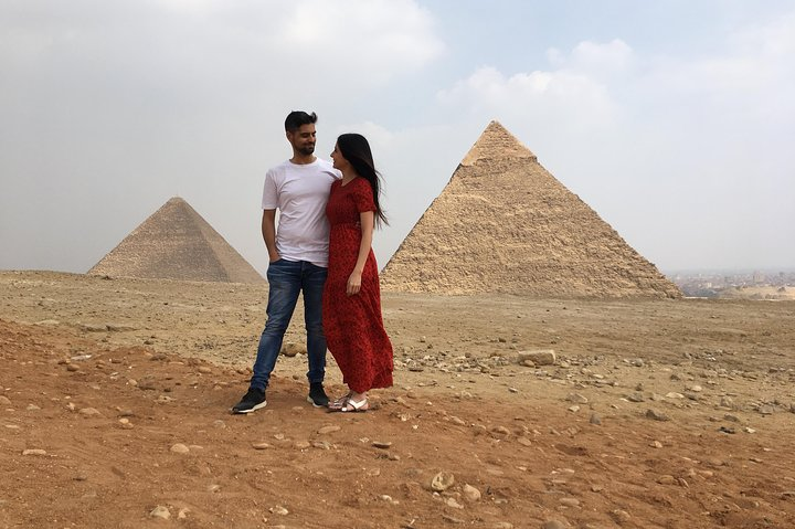 Standing amidst the majestic Giza Pyramids travelers create unforgettable memories as they immerse themselves in ancient wonders and share special moments against this iconic backdrop.