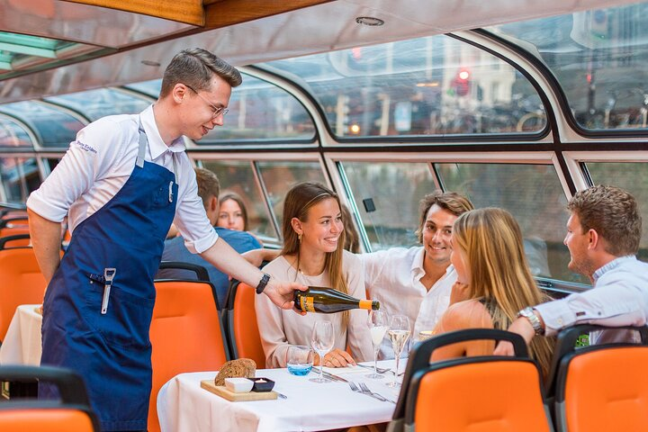 Savor a delightful 4-course dinner aboard a scenic canal cruise enjoying the charm of Amsterdam's canals while indulging in delicious food and drinks with friends.