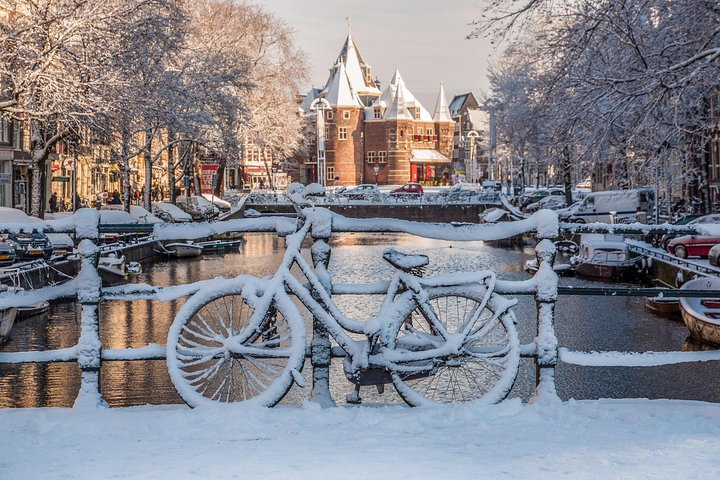 Wander through Amsterdam's snow-covered canals where charming bridges and quaint bicycles create a magical winter scenery that invites exploration of the city’s rich history and stunning architecture.