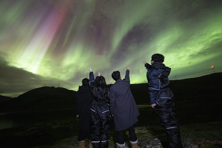 Experience the magic of the northern lights as friends share awe-inspired moments against a backdrop of stunning shimmering skies creating unforgettable memories in the Arctic wilderness.